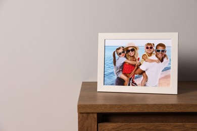 Photo of Frame with family photo on wooden chest of drawers, space for text