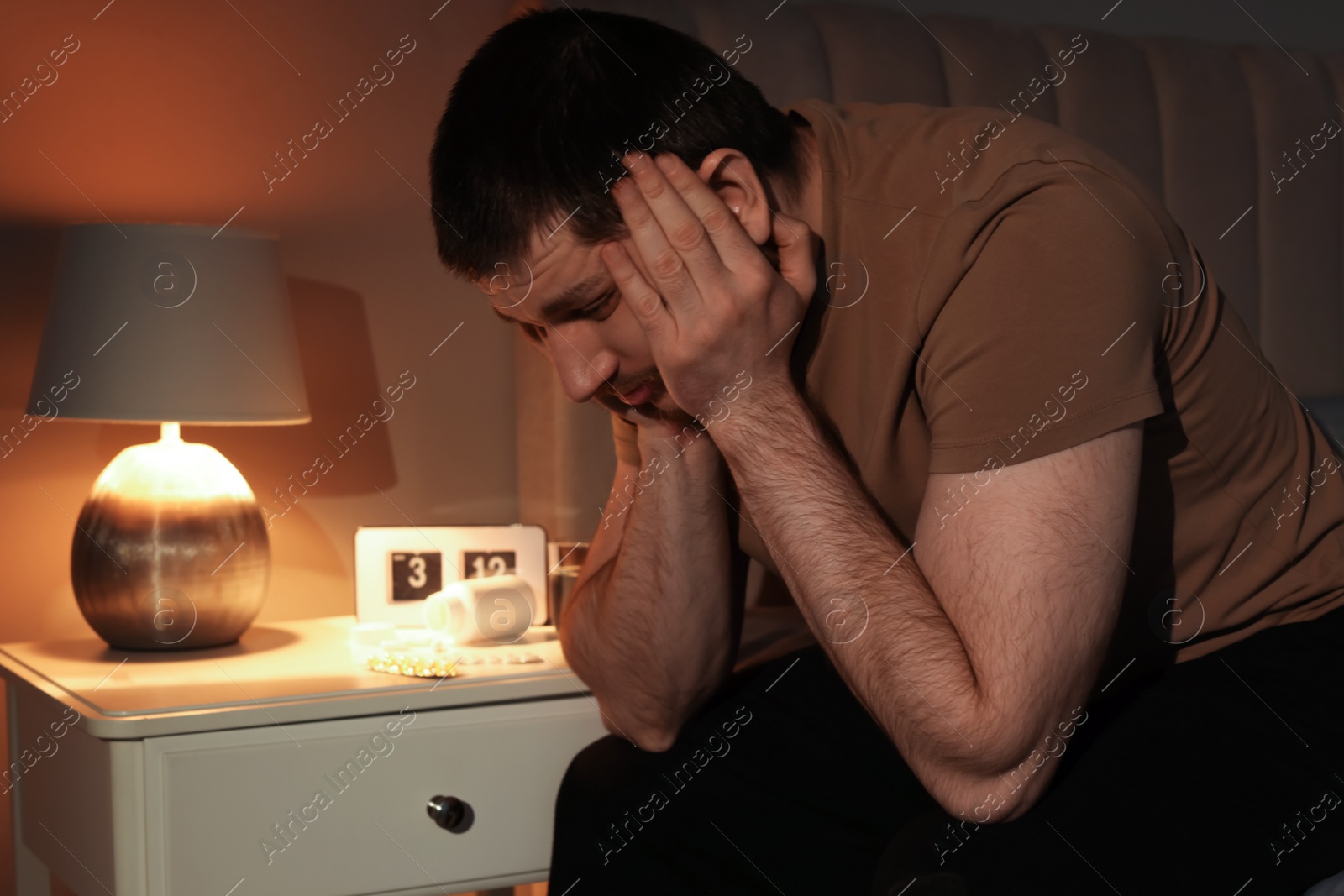 Photo of Man suffering from insomnia in bedroom at night