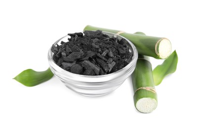 Photo of Fresh bamboo and charcoal on white background