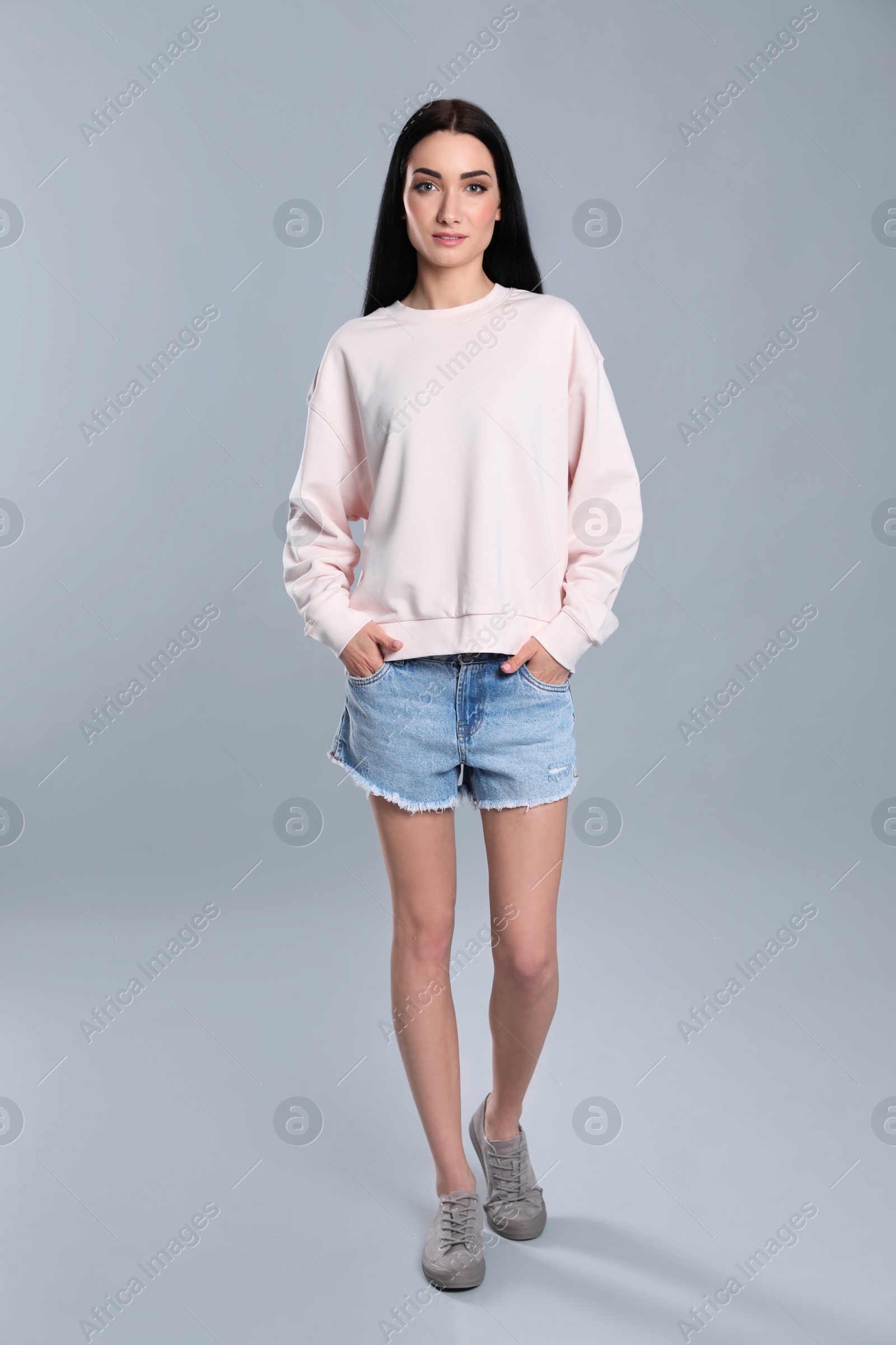 Photo of Full length portrait of young woman in sweater on grey background. Mock up for design