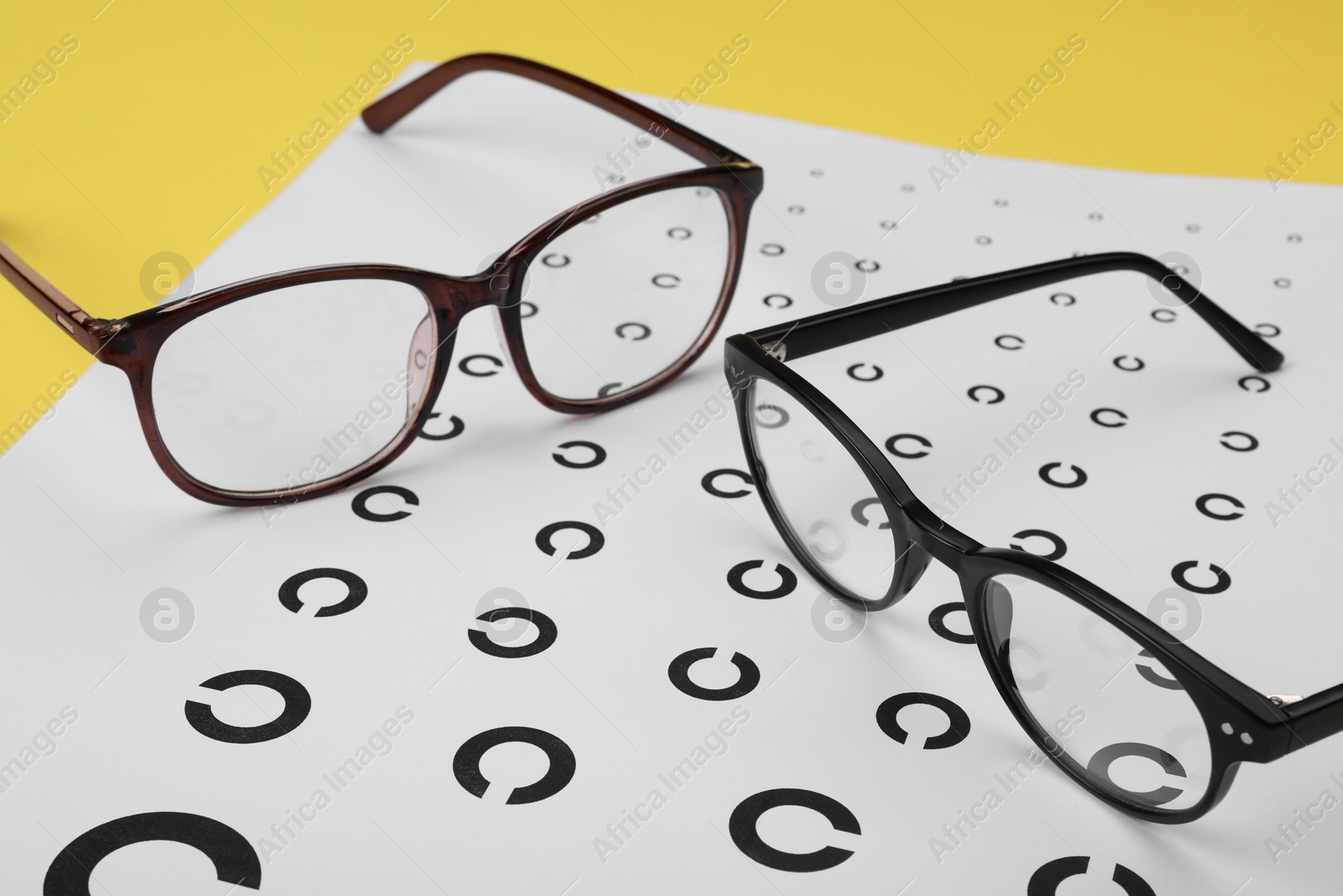 Photo of Vision test chart and glasses on table, closeup