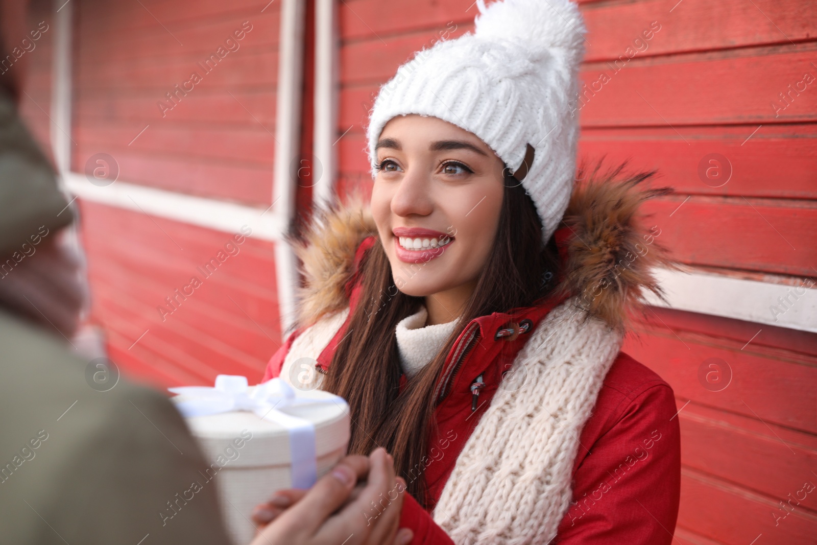 Photo of Happy young couple with gift box at winter fair. Christmas celebration