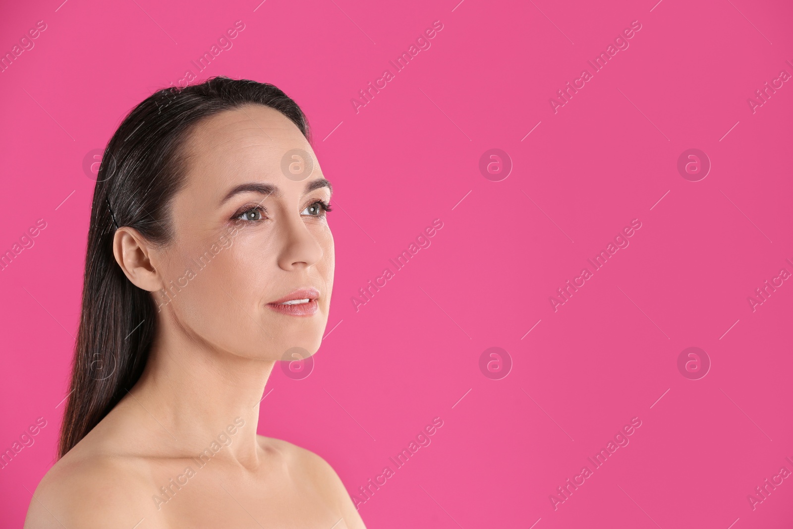 Photo of Portrait of beautiful mature woman on pink background. Space for text