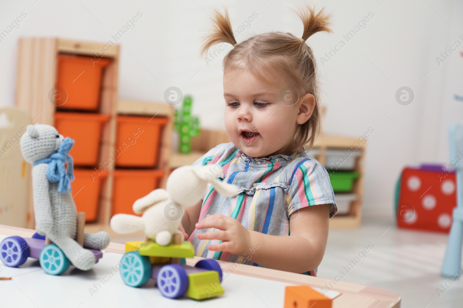 Photo of Little girl playing with toys at table