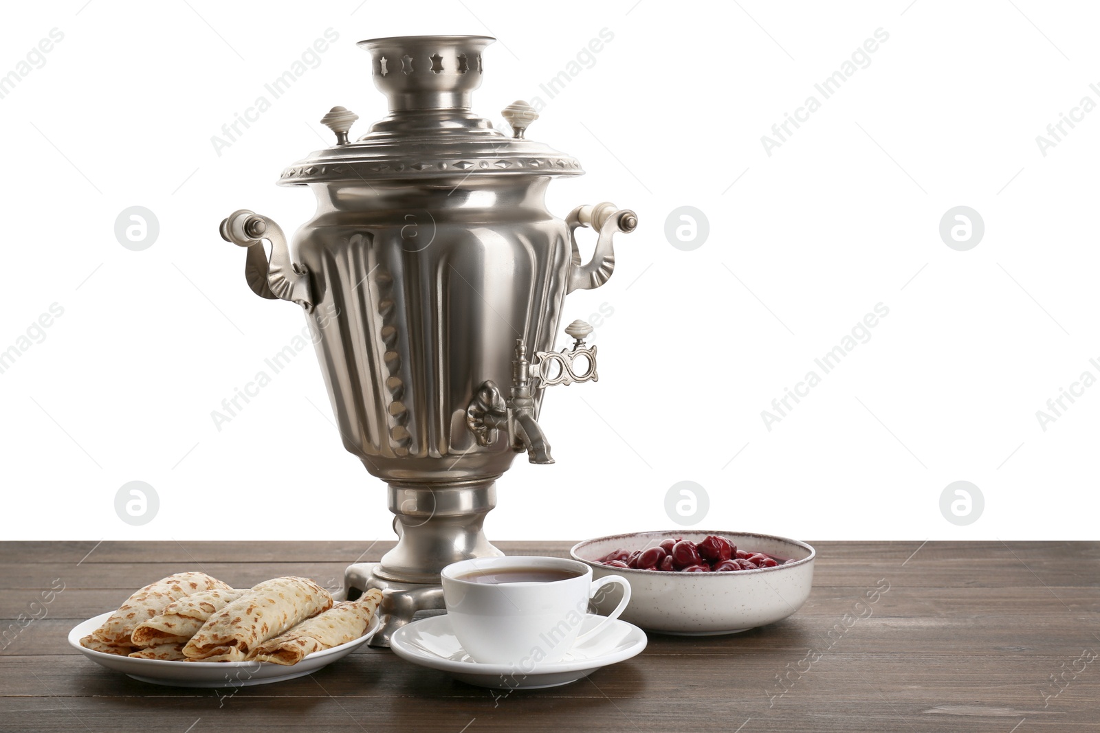 Photo of Vintage samovar, cup of hot drink and snacks on wooden table against white background, space for text. Traditional Russian tea ceremony