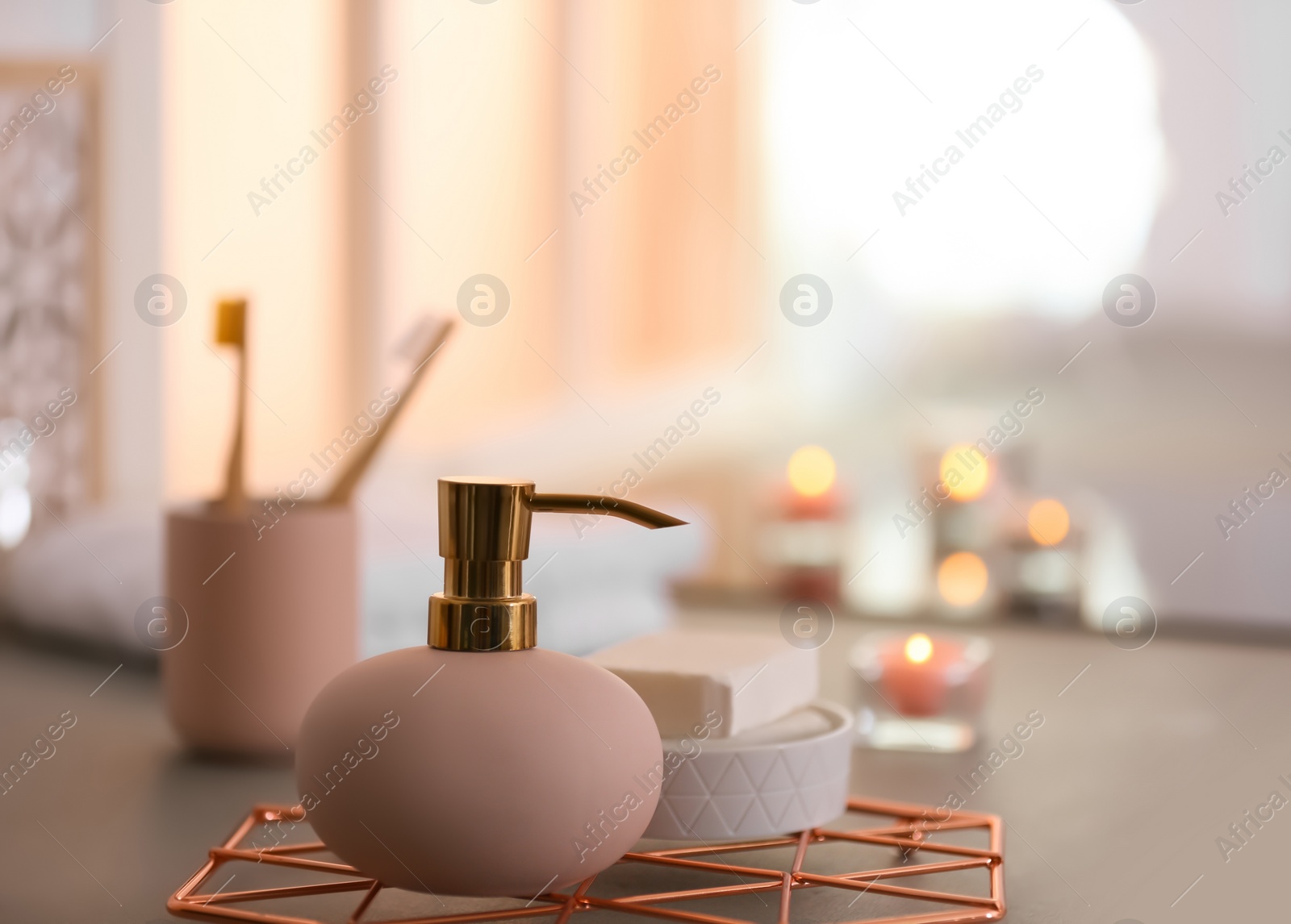 Photo of Bottle with liquid soap and toiletries on table against blurred background. Space for text