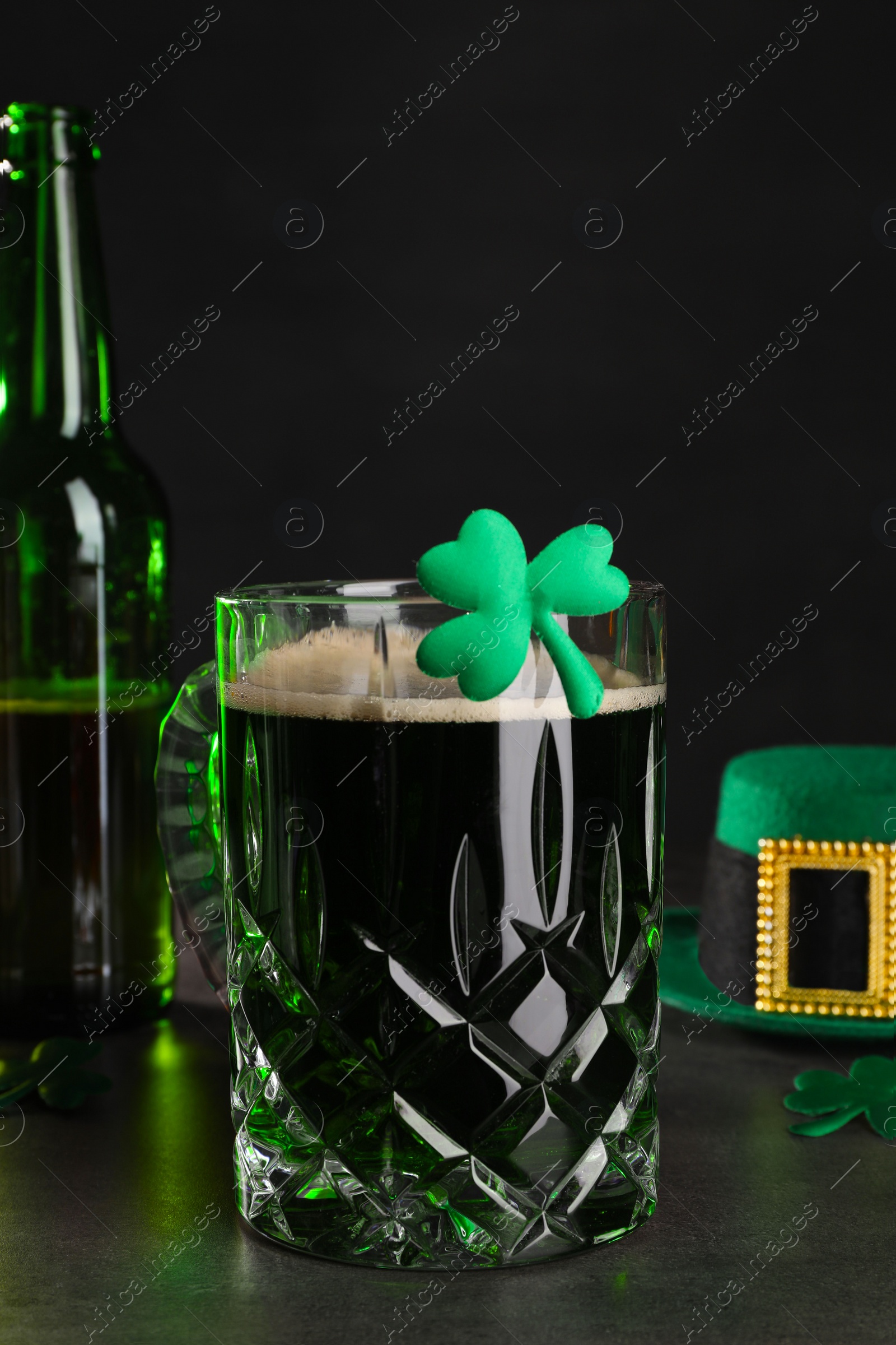 Photo of St. Patrick's day celebration. Green beer and decorative clover leaves on grey table
