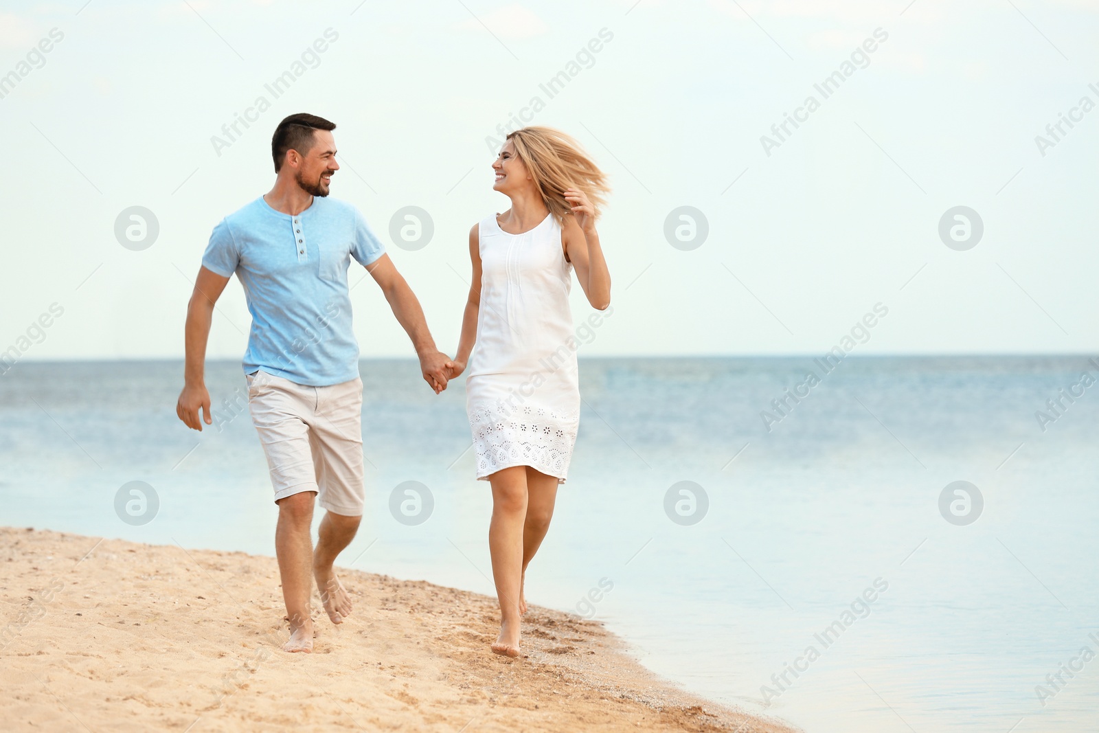 Photo of Happy romantic couple running together on beach, space for text