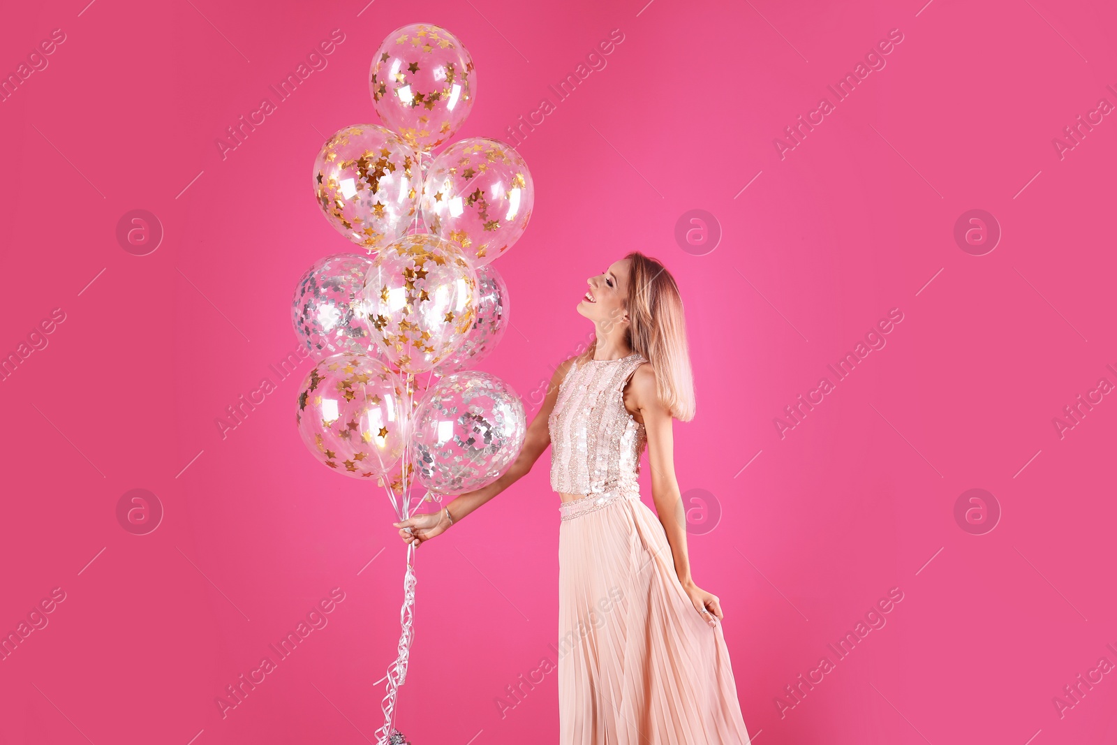 Photo of Young woman with air balloons on color background