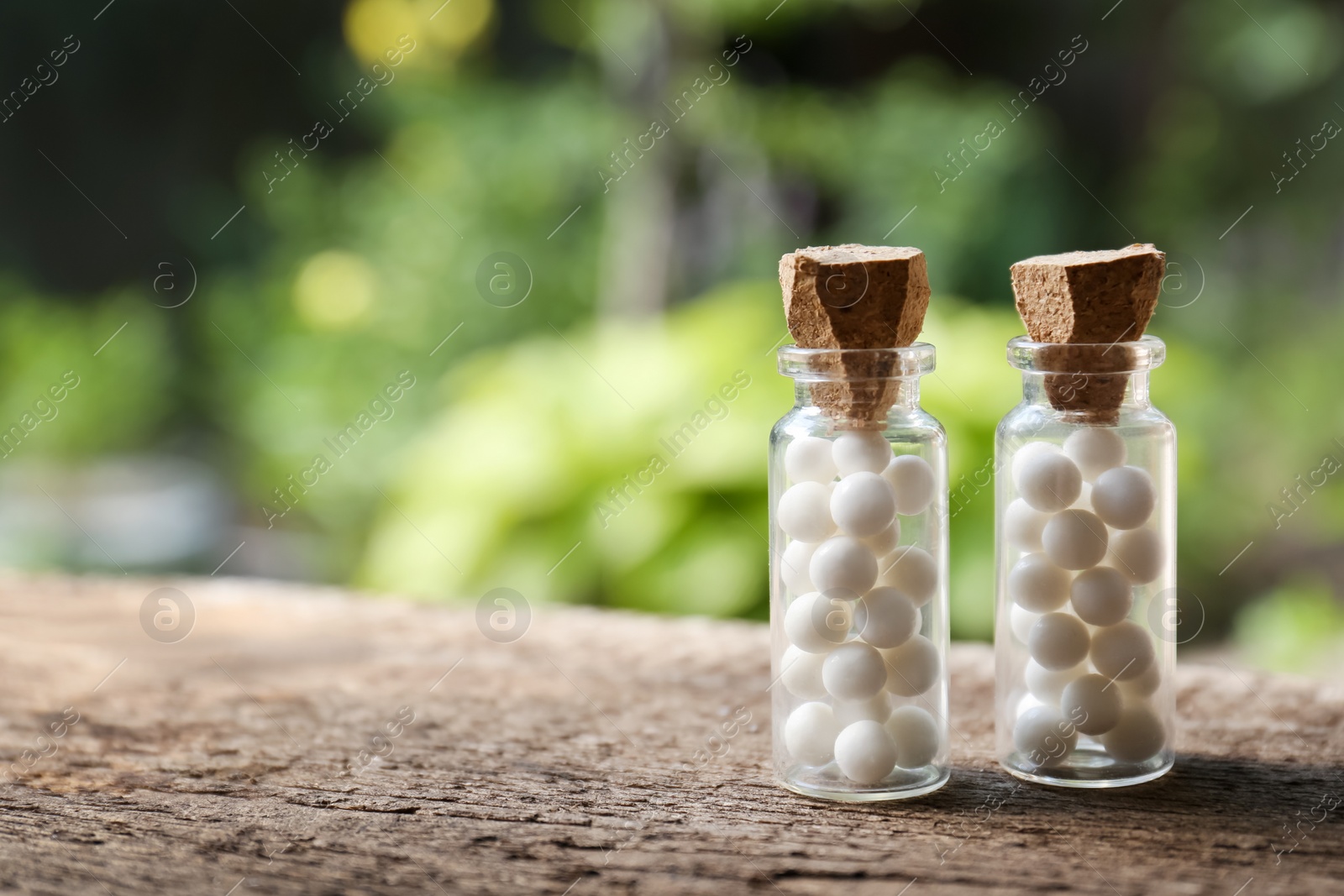 Photo of Bottles of homeopathic remedy on wooden table, space for text