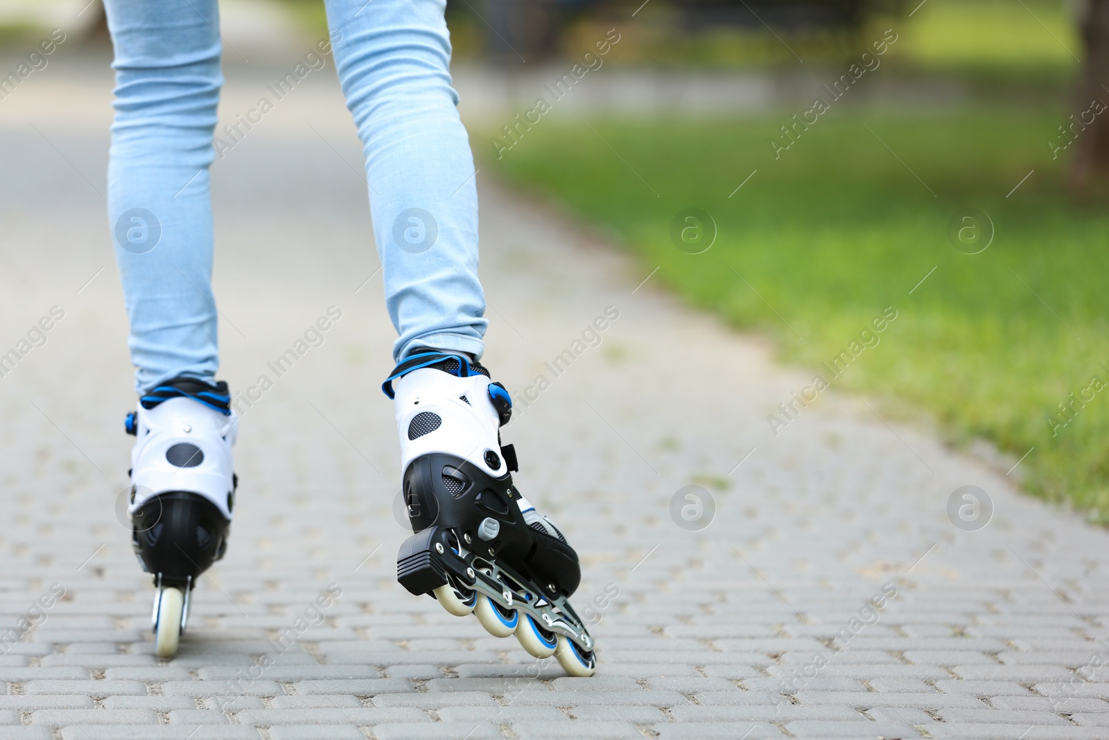 Photo of Woman roller skating on city street, closeup of legs