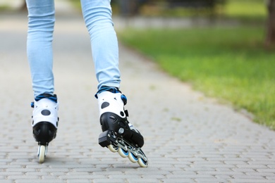 Photo of Woman roller skating on city street, closeup of legs