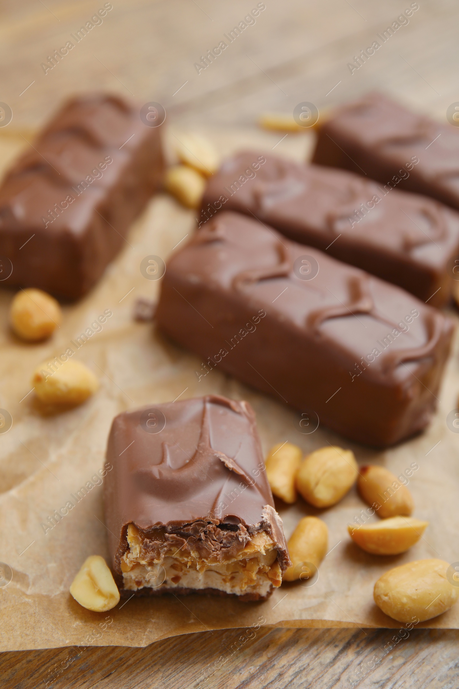 Photo of Chocolate bars with caramel, nuts and nougat on table