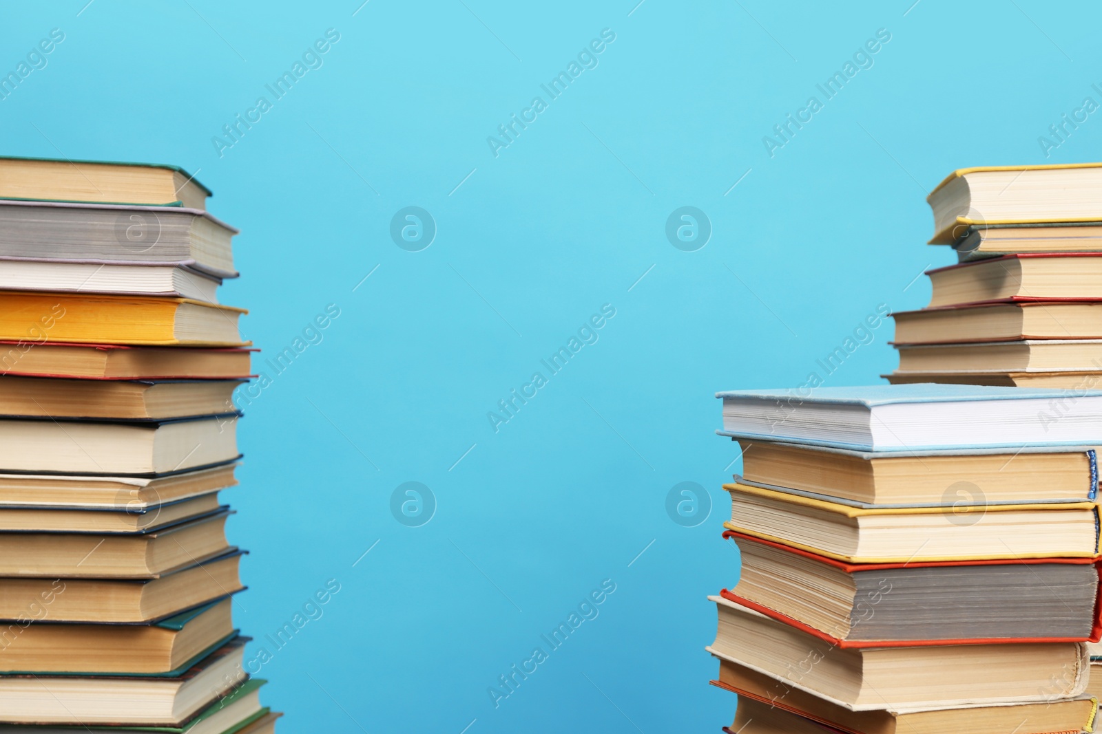 Photo of Many hardcover books on turquoise background, space for text. Library material