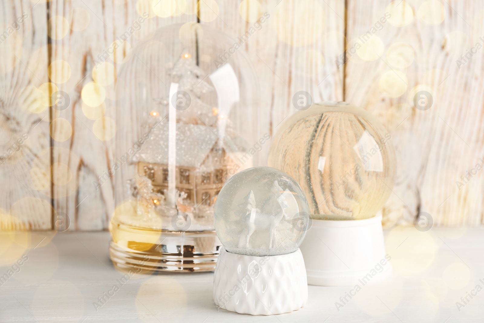 Image of Beautiful Christmas snow globes white table, bokeh effect