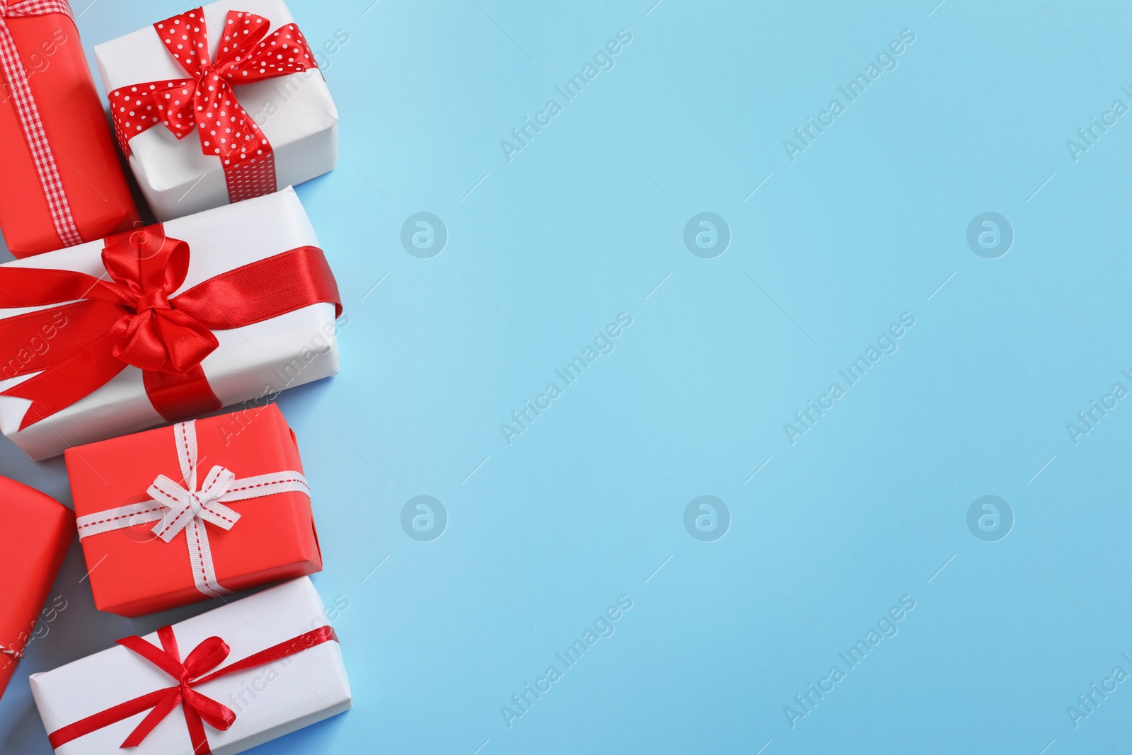 Photo of Beautifully wrapped gift boxes on color background, top view