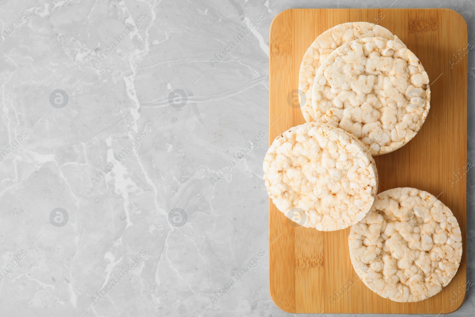 Photo of Crunchy rice cakes on grey marble table, top view. Space for text