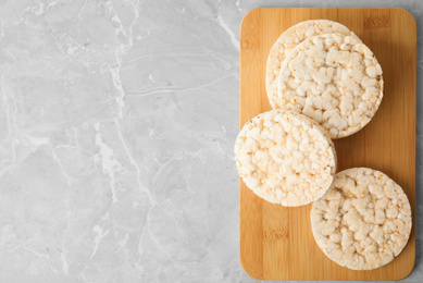 Photo of Crunchy rice cakes on grey marble table, top view. Space for text