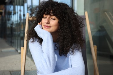 Photo of Young woman in stylish light blue sweater outdoors