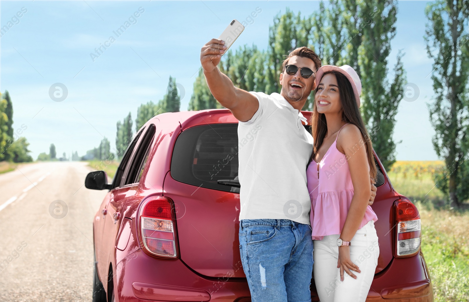 Photo of Happy young couple taking selfie near car on road