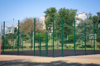 Photo of Empty basketball court outdoors on sunny day