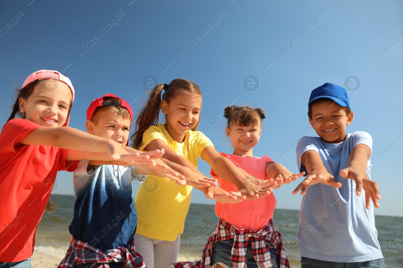 Photo of Group of happy children at sea beach on sunny day. Summer camp