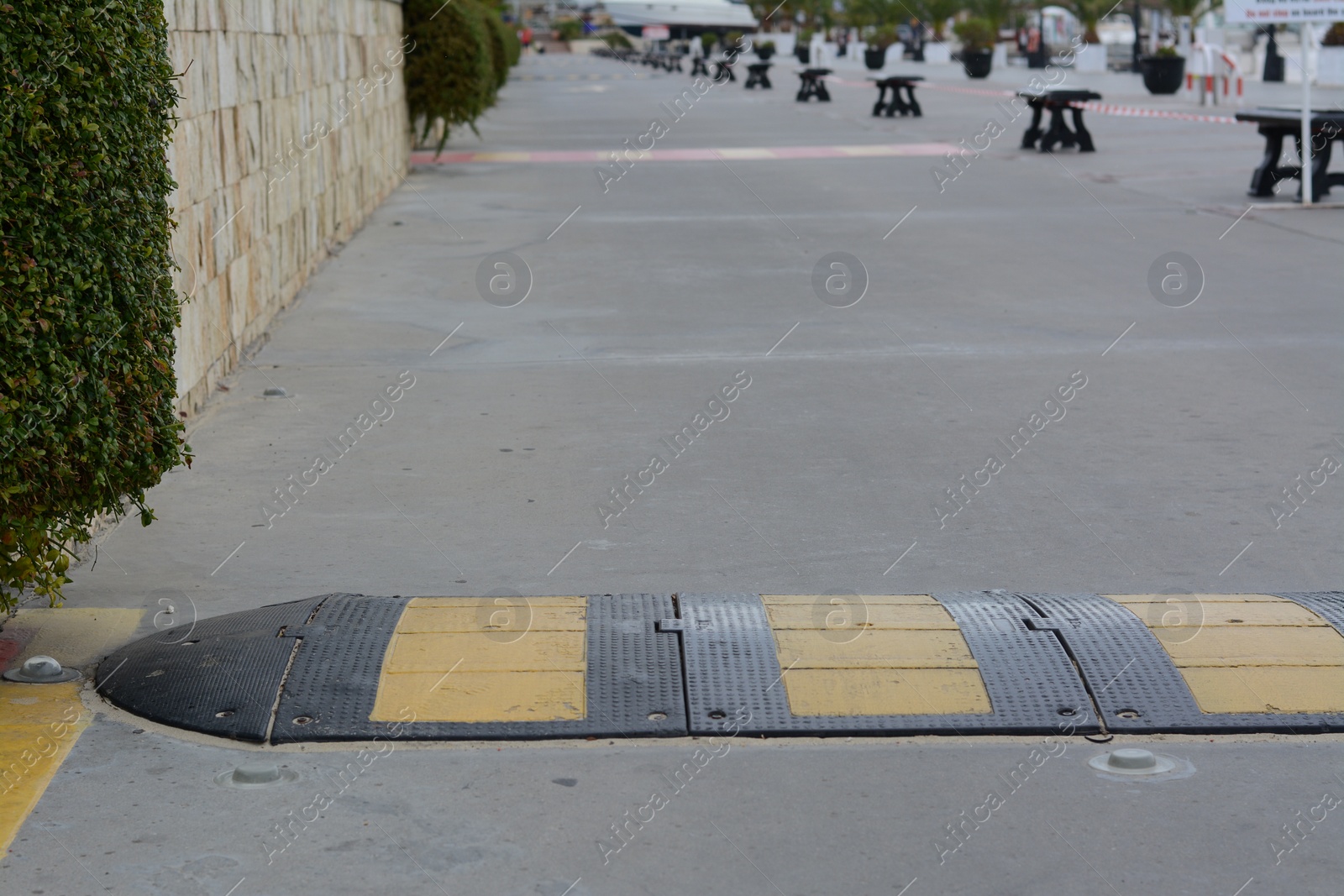 Photo of Striped rubber sleeping policeman on asphalt road