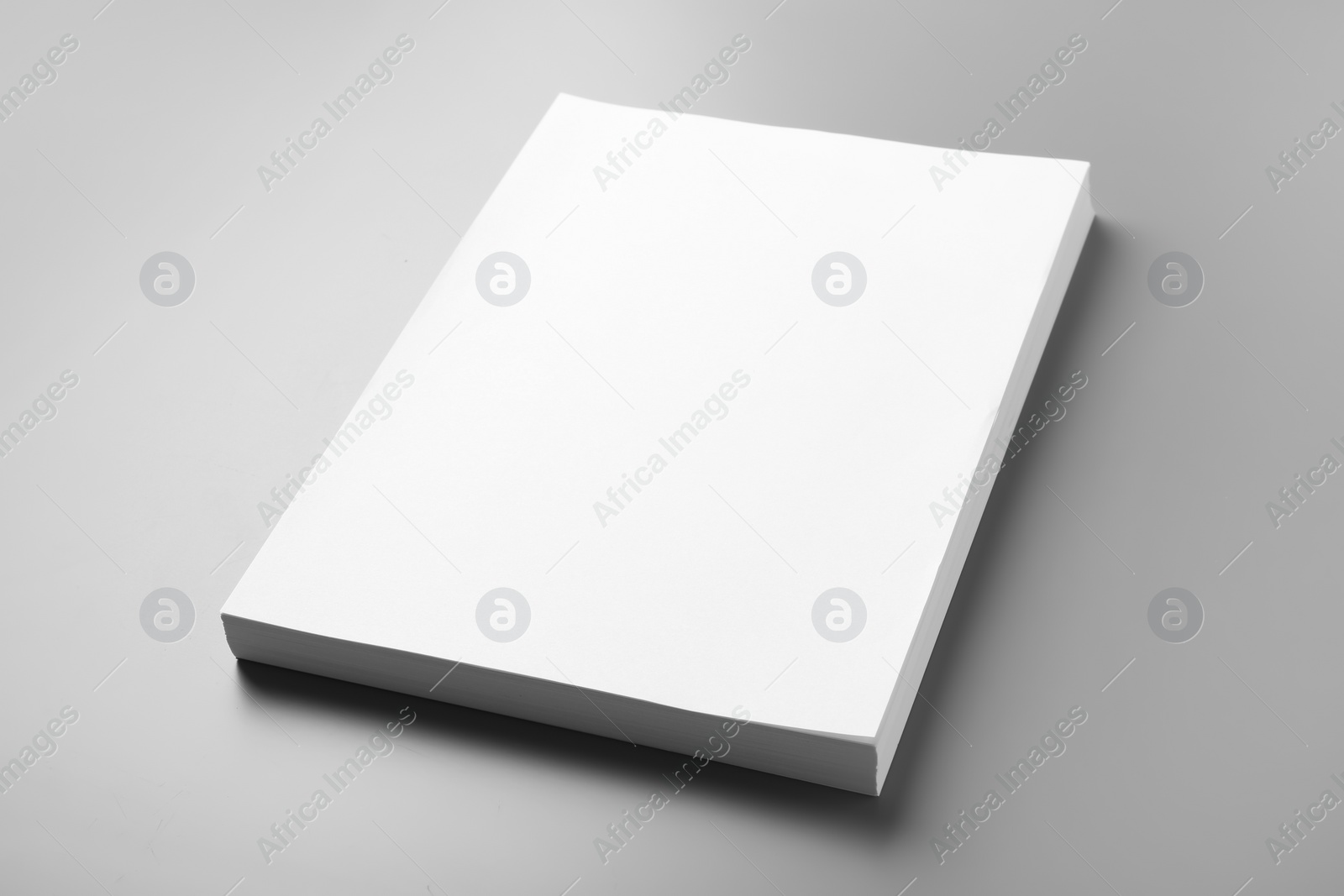 Photo of Stack of blank paper sheets for brochure on grey background. Mock up