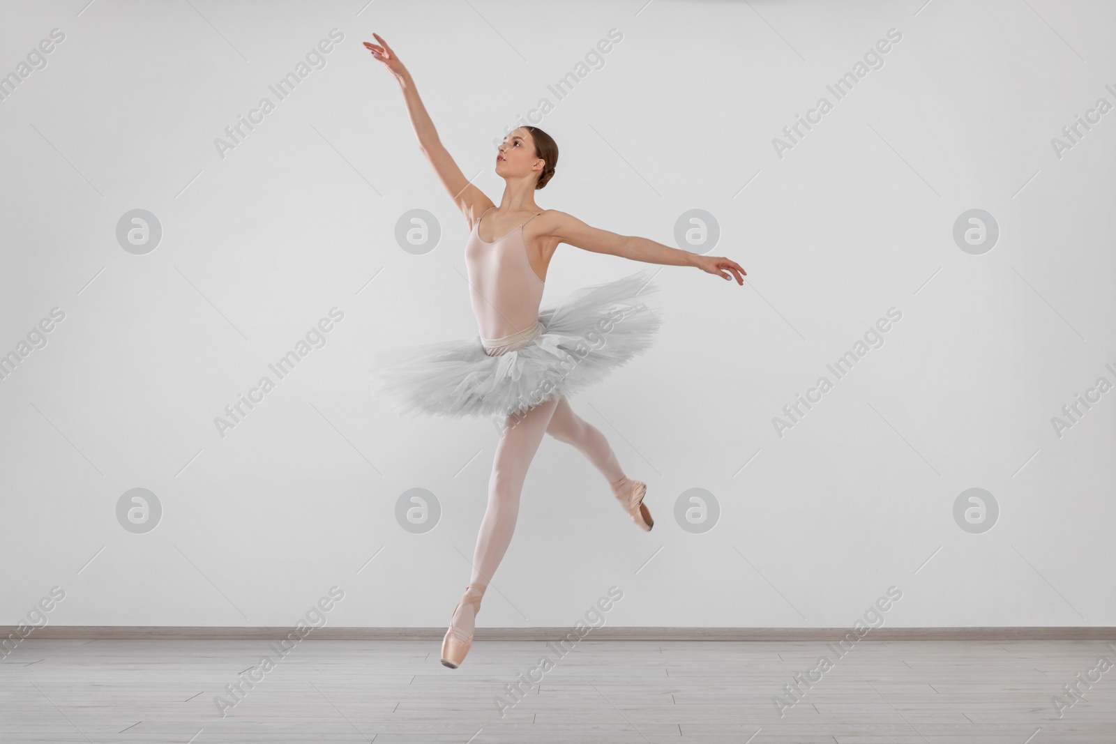 Photo of Young ballerina practicing dance moves in studio