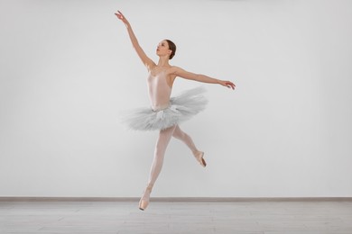 Photo of Young ballerina practicing dance moves in studio