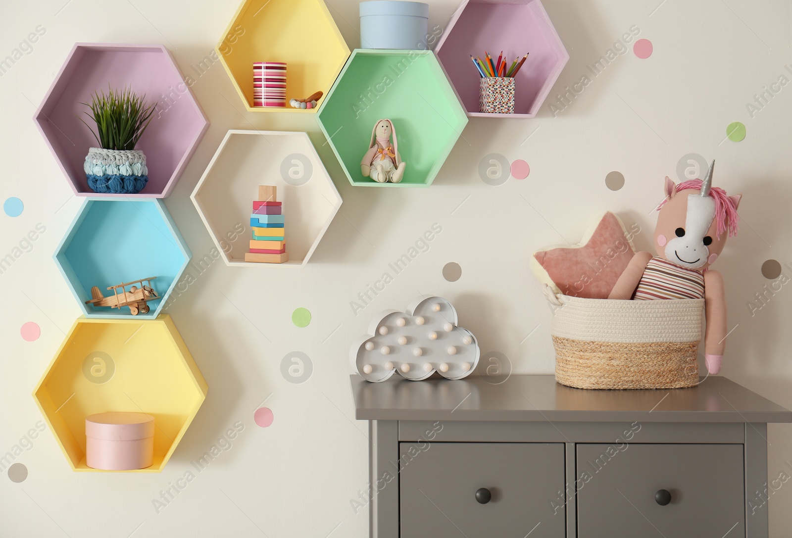 Photo of Bright colorful shelves on light wall in room. Interior design