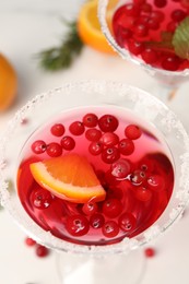 Photo of Tasty cranberry cocktail in glasses on white table, above view