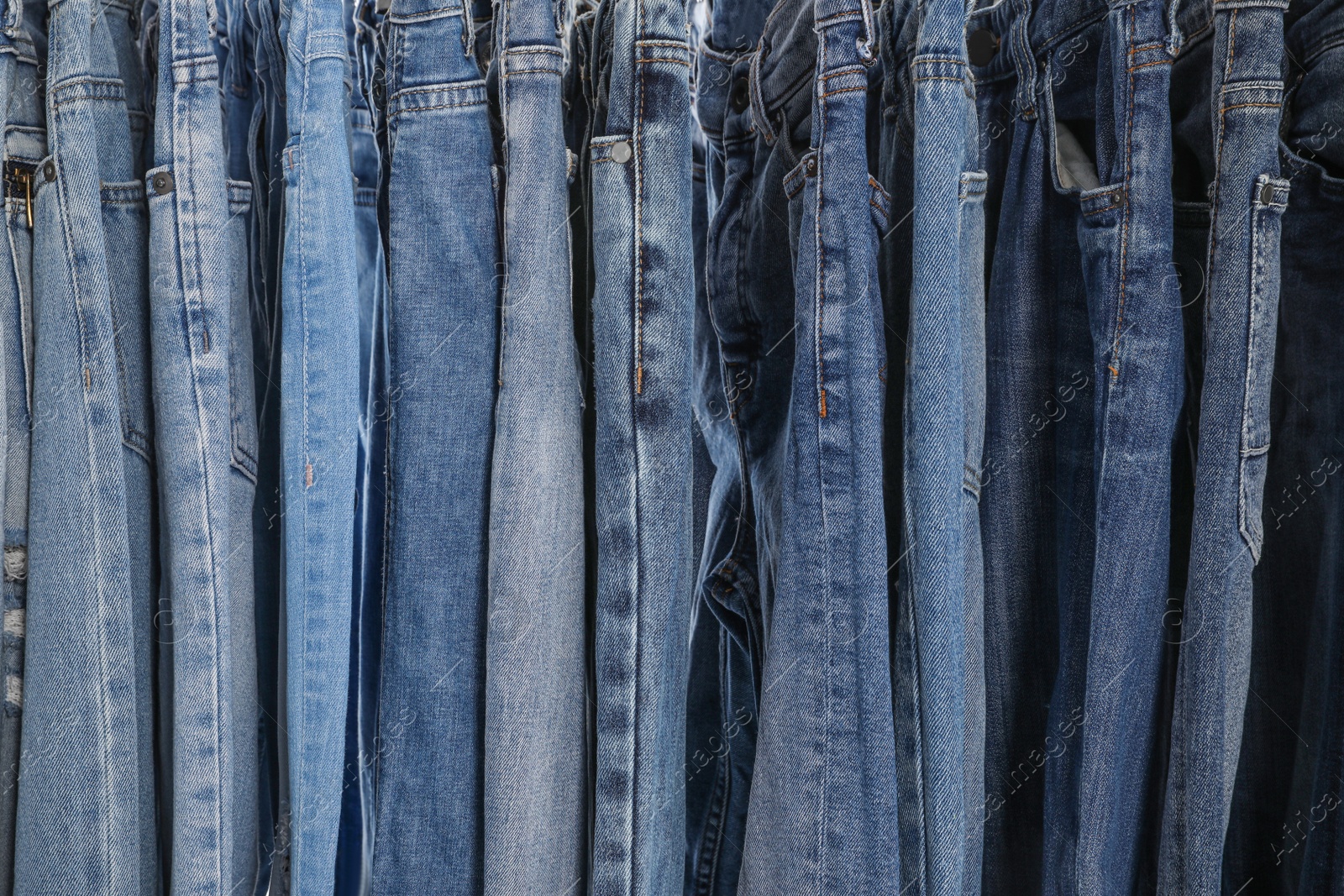Photo of Different stylish jeans as background, closeup view