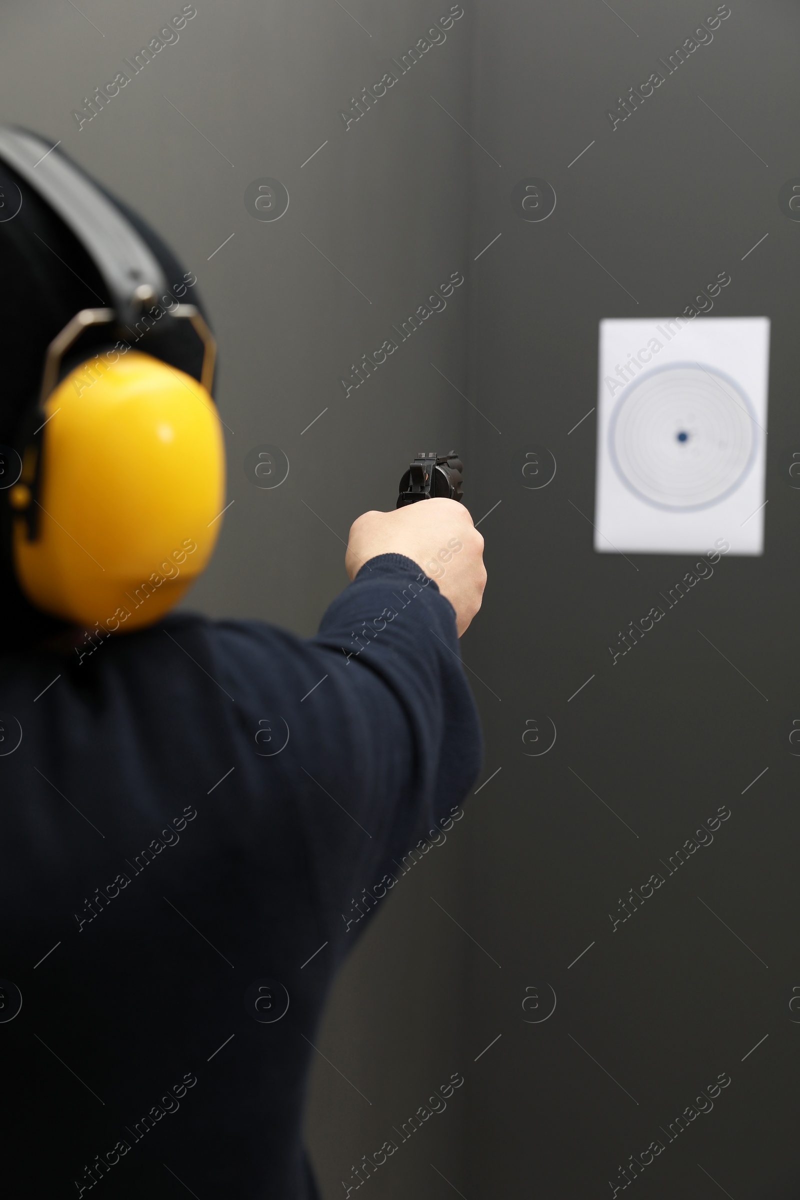 Photo of Man aiming at shooting target indoors, closeup