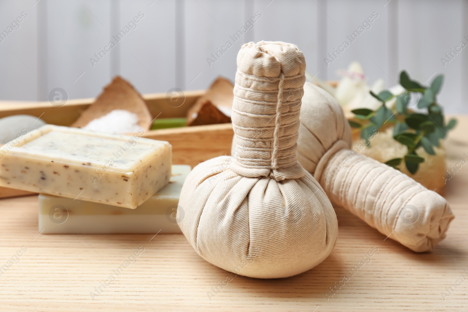 Photo of Herbal balls and soap on table, closeup. Spa treatment