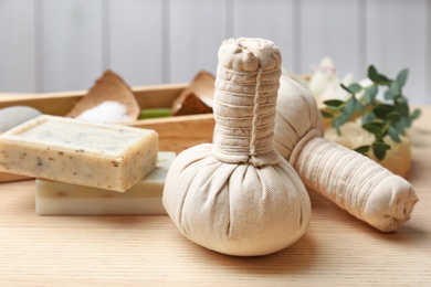 Photo of Herbal balls and soap on table, closeup. Spa treatment