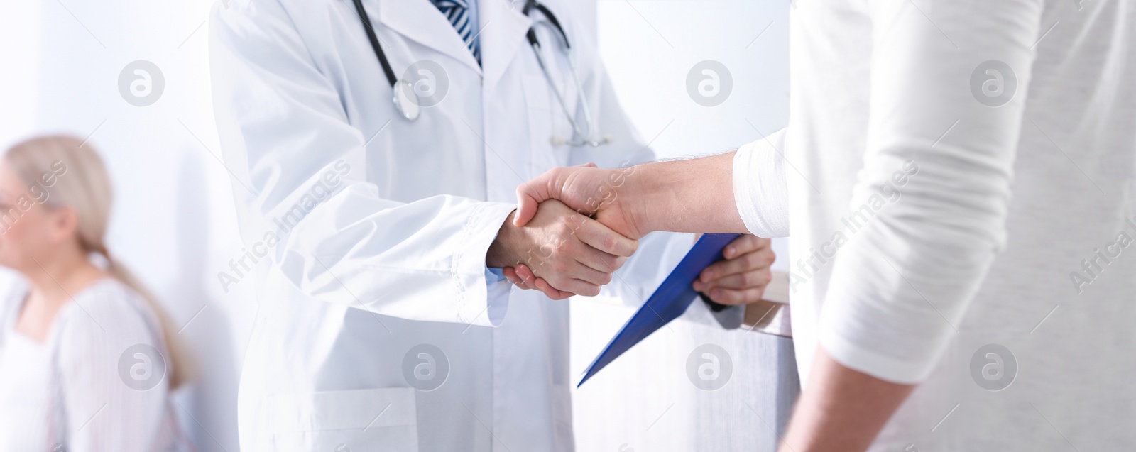 Image of Doctor and patient shaking hands in hospital hall, closeup. Banner design