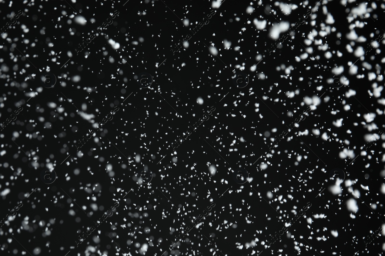 Photo of White snow falling down on black background