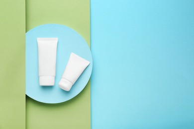 Photo of Tubeshand cream on turquoise background, flat lay. Space for text