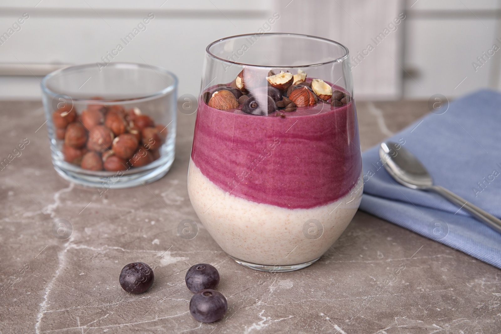 Photo of Glass with tasty acai smoothie on gray table