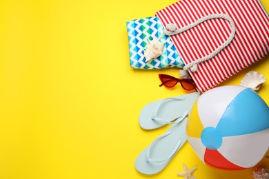 Photo of Flat lay composition with ball and beach objects on yellow background, space for text