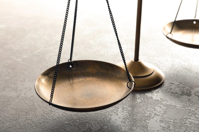 Photo of Scales of justice on table, closeup. Law concept