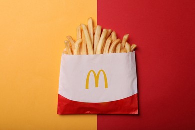 MYKOLAIV, UKRAINE - AUGUST 12, 2021: Small portion of McDonald's French fries on color background, top view