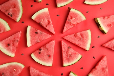 Slices of ripe watermelon on red background, flat lay