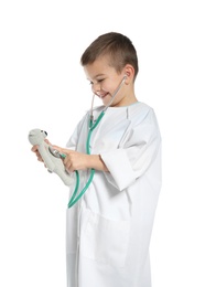 Photo of Cute child imagining himself as doctor while playing with stethoscope and toy on white background