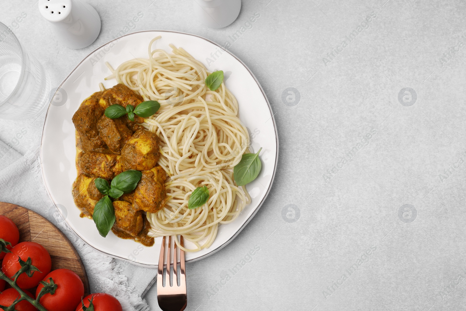 Photo of Delicious pasta and chicken with curry sauce served on white table, flat lay. Space for text