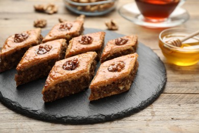 Delicious honey baklava with walnuts served on wooden table, closeup