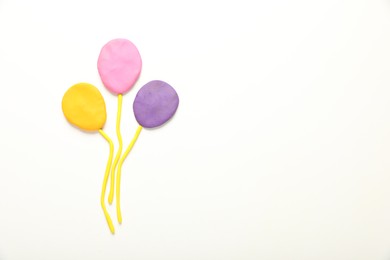 Photo of Beautiful balloons made of plasticine on white background, top view