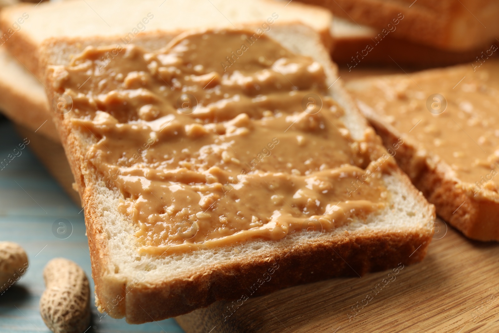 Photo of Delicious toasts with peanut butter on table, closeup