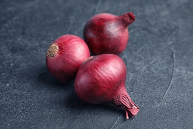 Photo of Ripe red onions on table